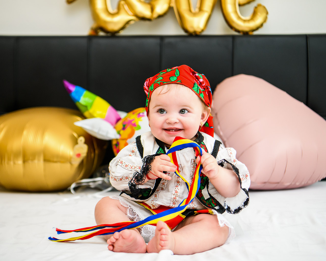 Fotograf botez Bucuresti – fetiță în costum popular cu batic roșu și tricolor